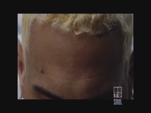 The back of a person's head is in view, with a small triangle tattoo just below the hairline. The logo for BET Soul is visible in the corner.

