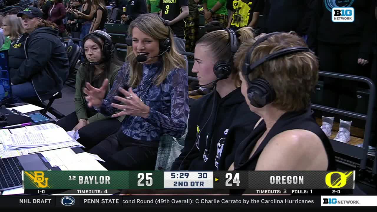A woman in a patterned blouse gestures emphatically as she speaks into a microphone. The Big Ten Network logo is visible, and the scoreboard shows a close basketball game between Baylor and Oregon.
