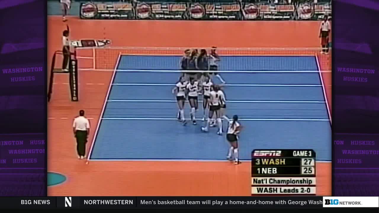 The Washington Huskies volleyball team huddles on the court, celebrating a point. A referee stands on the sideline, watching the action in the National Championship game broadcast on the Big Ten Network.
