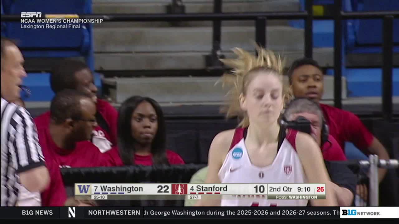 A Stanford player, in a red and white jersey, runs toward the camera, her blonde hair flying back. Behind her, the bench watches the game intently during the second quarter of the NCAA Women's Championship, as shown on the Big Ten Network.
