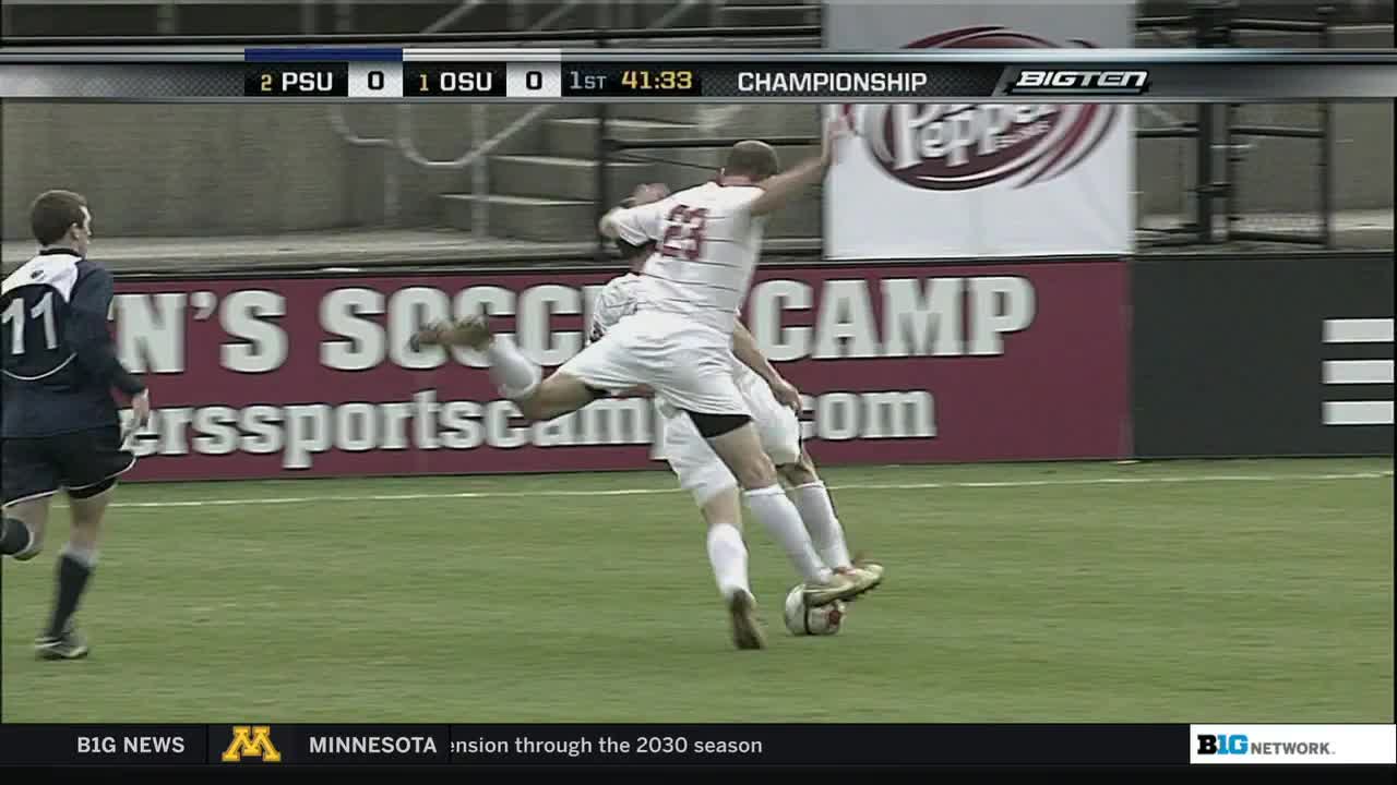 A Penn State player, number 23, stretches his leg high to kick the ball, while an Ohio State player is close behind. The score is 2-0 in the first half, and the Big Ten Network logo is visible in the corner.
