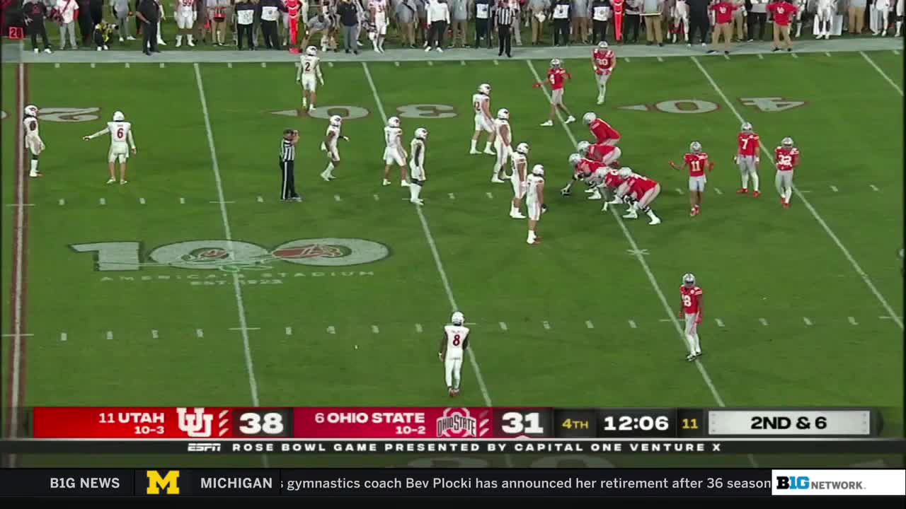 Ohio State's offense is lined up, ready for the snap, while Utah's defense watches from across the field. The clock shows just over twelve minutes left in the fourth quarter, and it's a close game.

