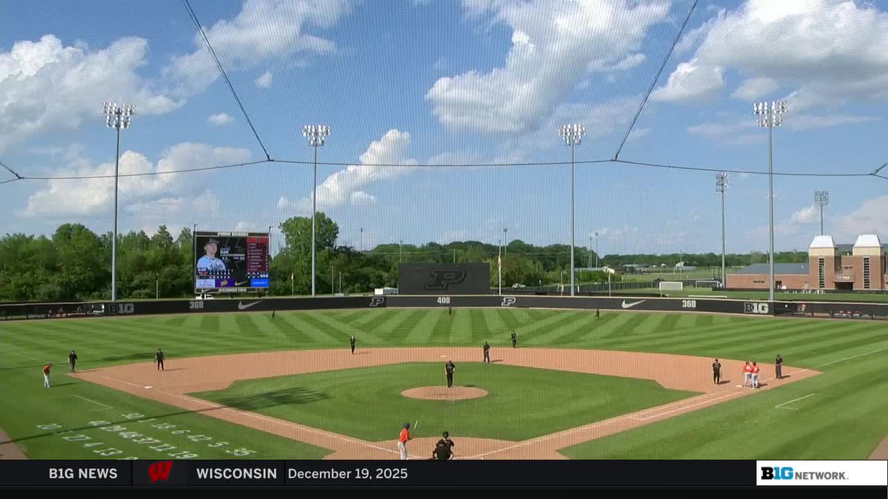 A baseball field is bathed in sunlight, with players scattered across the diamond. The Big Ten Network logo is visible in the corner of the screen.
