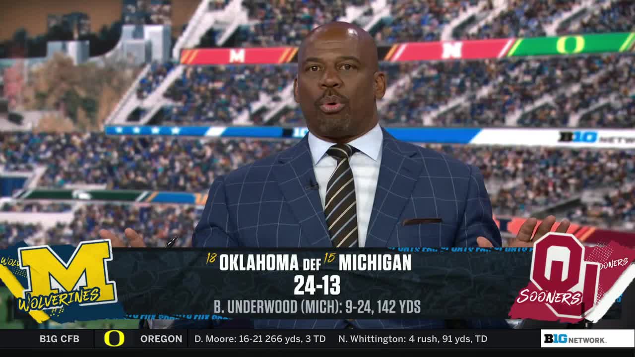 A commentator in a suit gestures with both hands, speaking directly to the camera on the Big Ten Network. Graphics display the score of a college football game between Oklahoma and Michigan.
