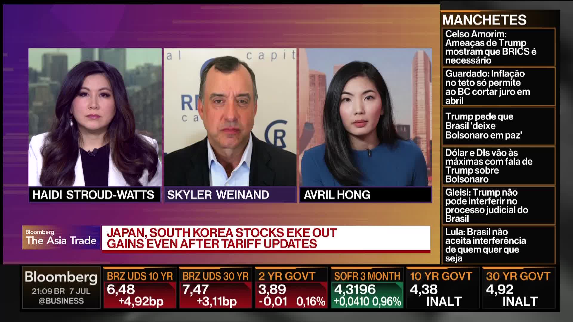 Three people on Bloomberg TV in the United States are discussing financial news, with stock market data displayed at the bottom of the screen. The broadcast features a headline about Japan and South Korea stocks.
