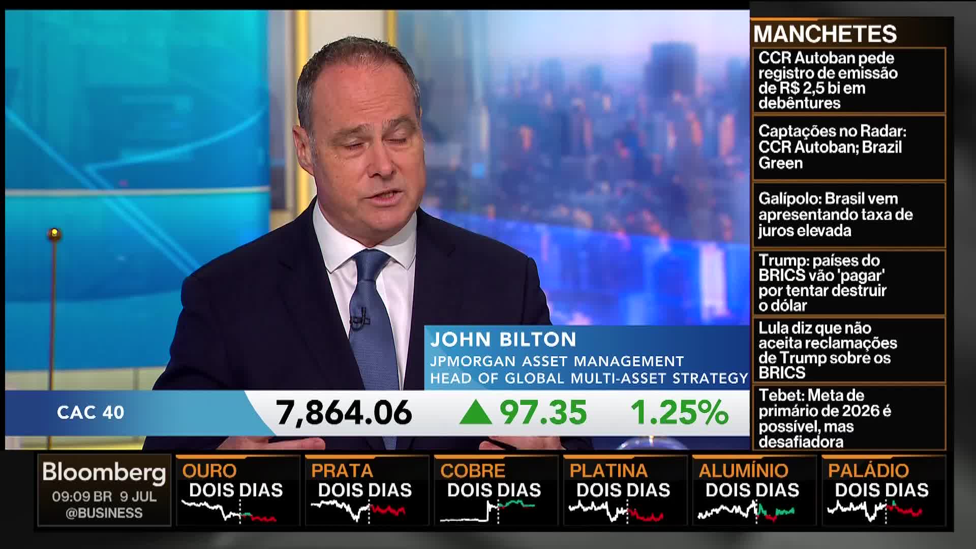 A man in a suit, John Bilton of JPMorgan, is speaking on Bloomberg TV, with financial data displayed below. Headlines in Portuguese scroll on the right, while the CAC 40 index and commodity prices are shown at the bottom.
