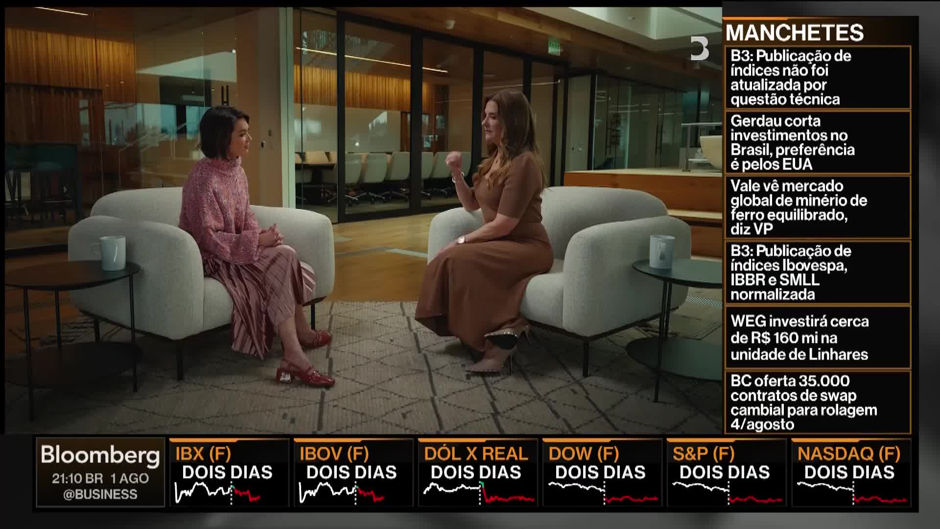 Two women are seated in armchairs, engaged in a discussion on a Bloomberg TV set. The woman on the right gestures with her hand as she speaks.
