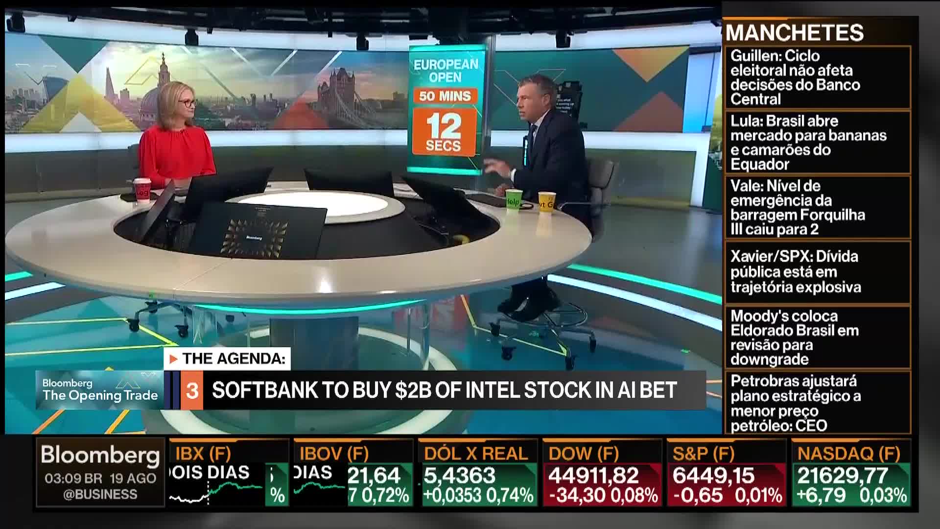 On the Bloomberg TV set, two people are seated at a curved desk, discussing financial news. A clock counts down the seconds until the European markets open, while stock market data scrolls across the bottom of the screen.
