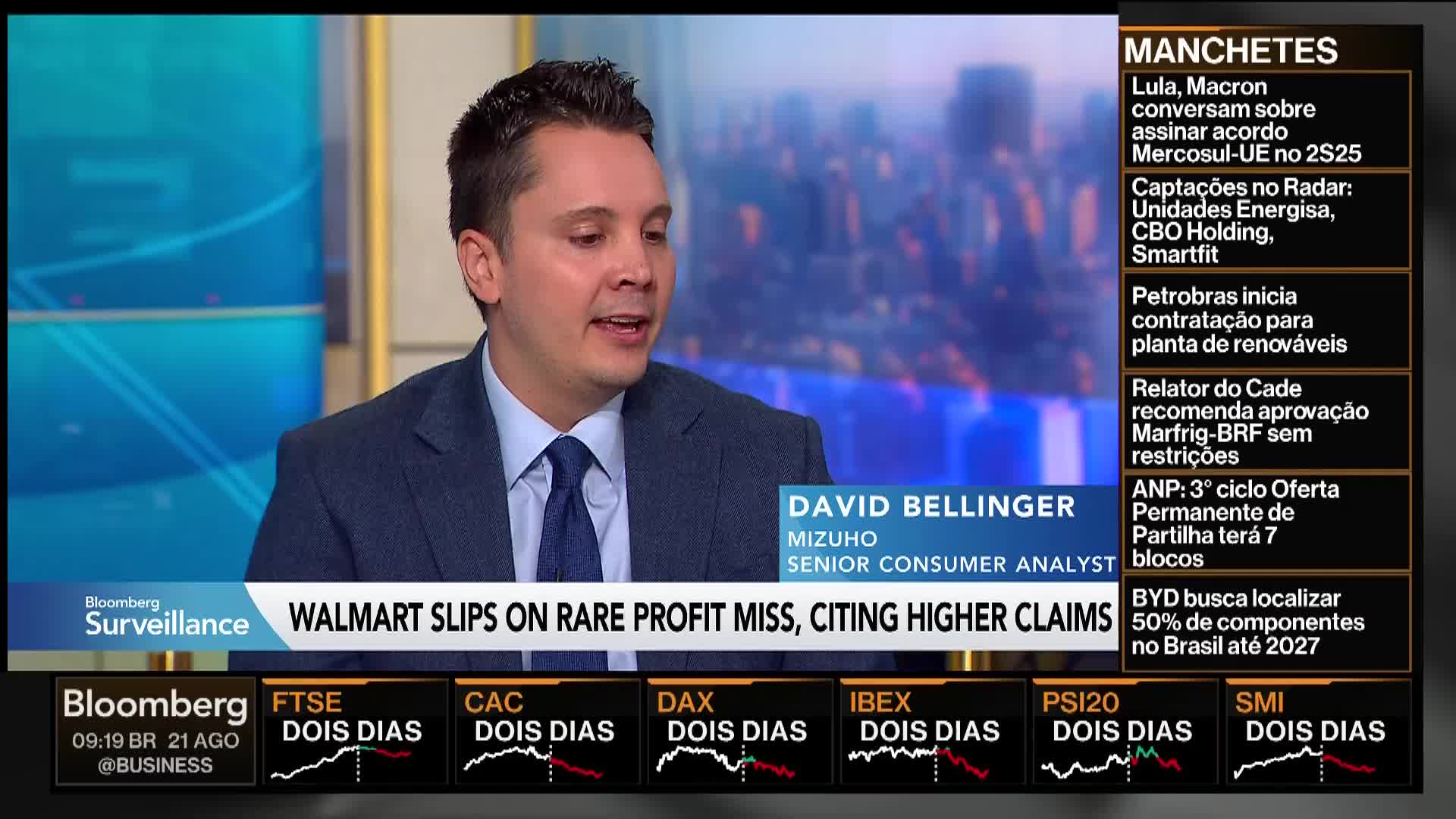 A man in a suit and tie, identified as a Senior Consumer Analyst for Mizuho, is speaking on Bloomberg TV. The bottom of the screen displays stock market information and the headline "Walmart slips on rare profit miss."
