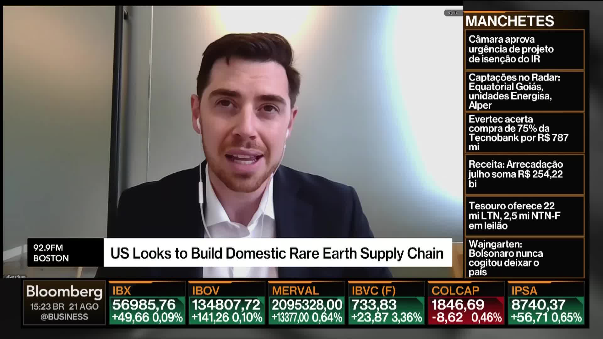 A man in a suit jacket, wearing an earpiece, speaks animatedly on Bloomberg TV. Below, financial data scrolls across the screen, and the headline "US Looks to Build Domestic Rare Earth Supply Chain" is displayed.
