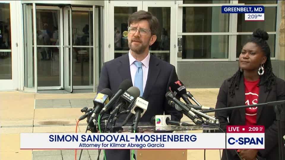 A man in a suit, identified as an attorney, speaks into a cluster of microphones, with a woman standing beside him. The C-SPAN logo is visible, indicating a live broadcast from Greenbelt, Maryland.
