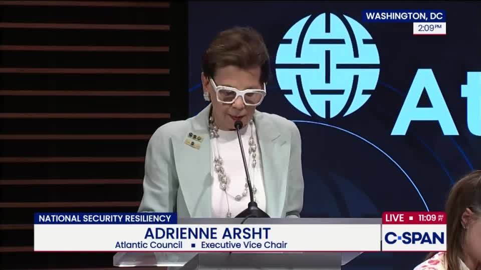 Adrienne Arsht, Executive Vice Chair of the Atlantic Council, speaks at a podium in Washington, D.C., as shown live on C-SPAN. She wears a light-colored blazer and large white-framed glasses, reading from a script.
