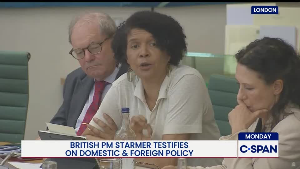 A woman with curly hair speaks animatedly, gesturing with her hands.  The C-SPAN banner indicates a British Prime Minister is testifying on domestic and foreign policy.
