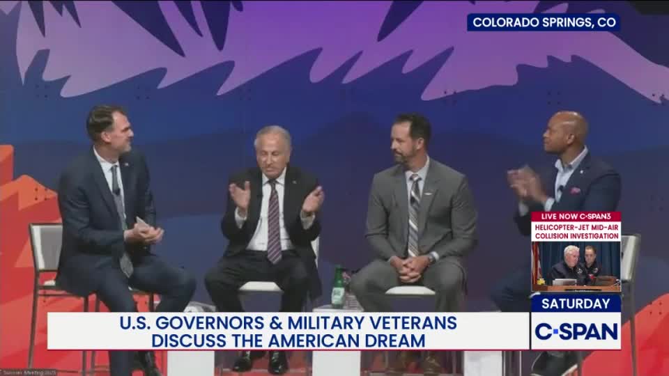 Four men in suits are seated on stage, gesturing as they speak. The C-SPAN graphic in the corner indicates a discussion about the American Dream is underway in Colorado Springs.
