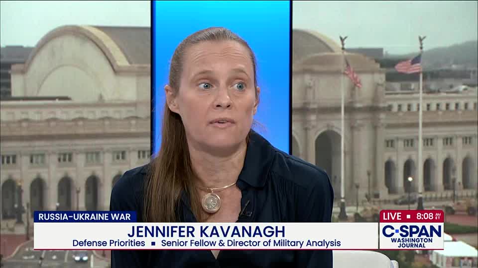 On C-SPAN, Jennifer Kavanagh is speaking, her face framed by a blue backdrop. The background shows a building in Washington, D.C., with American flags waving.
