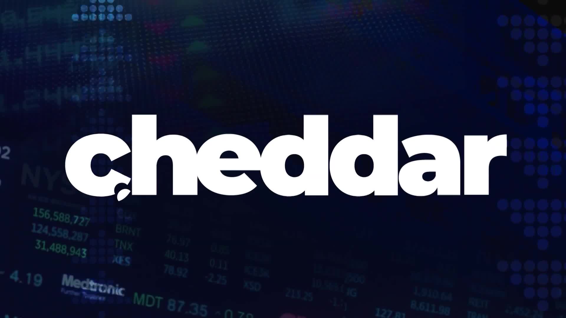 The word "cheddar" is in bold white letters, centered against a dark blue backdrop. Behind the logo, stock market data floats in the background.
