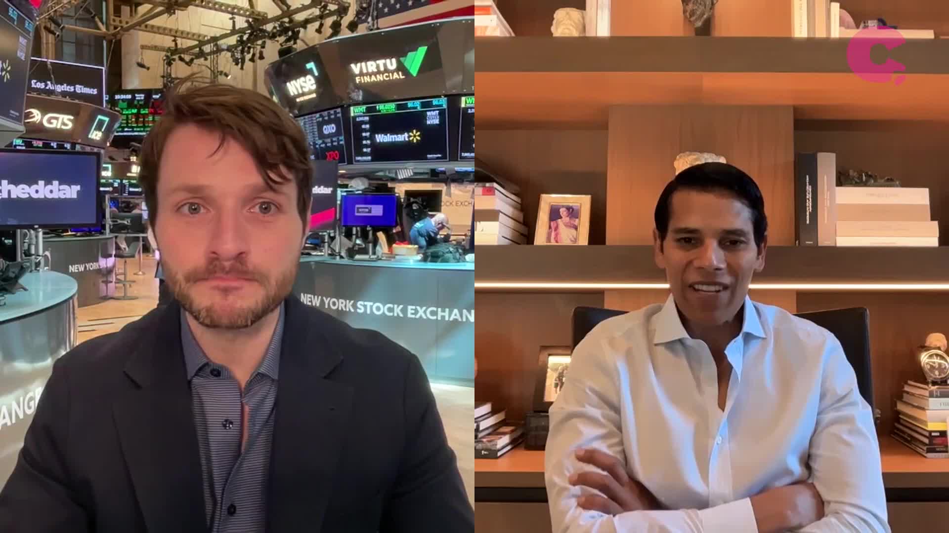 The Cheddar News host, standing in the New York Stock Exchange, is interviewing a man in a button-down shirt. The man on the right is smiling, while the host looks directly at the camera.
