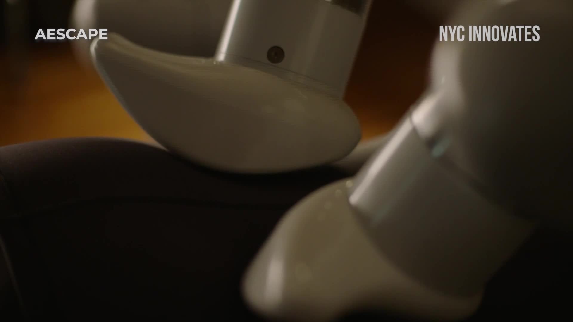 White, rounded robotic limbs are positioned over a dark, possibly upholstered surface. The scene, labeled "NYC Innovates" by Cheddar News, suggests a focus on technology and innovation in the United States.
