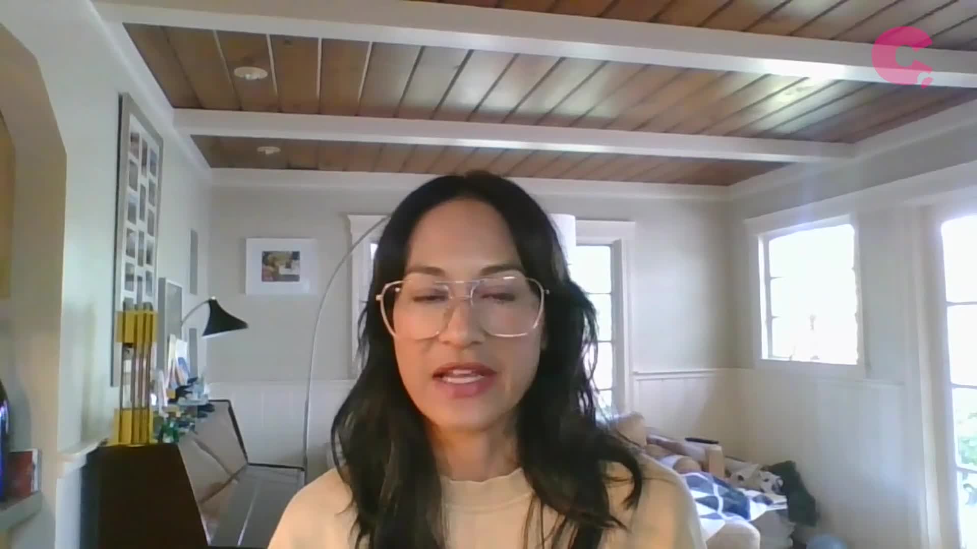 A woman with glasses is speaking, her mouth moving as she addresses the camera.  Behind her, a logo for Cheddar News is visible in the upper right corner.
