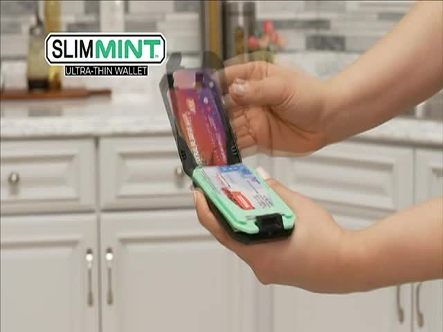 A hand flips open a mint-green wallet, revealing several cards inside. The wallet's lid moves quickly, showcasing the product on CNBC World.
