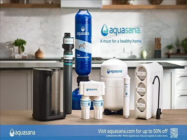 A collection of water filtration systems, branded with the "aquasana" logo, are arranged on a wooden surface. The backdrop is a modern kitchen, suggesting a focus on home health.
