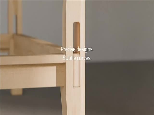 A close-up shows a wooden chair leg with a precisely cut mortise and tenon joint. The light-colored wood is set against a neutral background.
