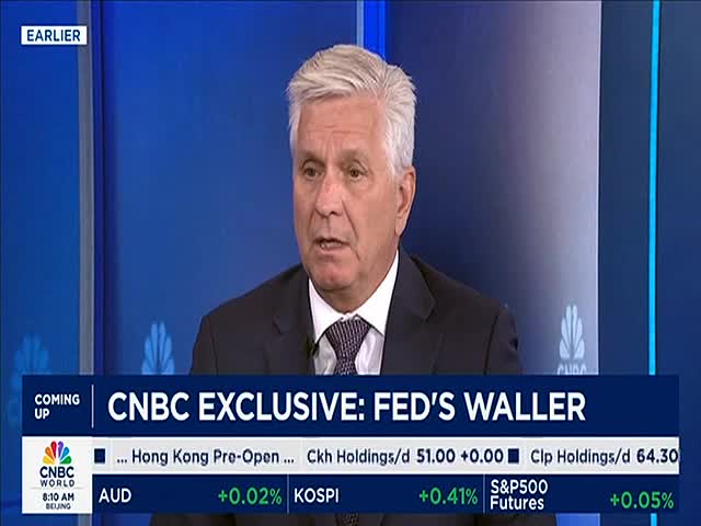A man in a suit speaks, framed by a blue backdrop on CNBC World. The lower third of the screen displays market data and the headline "CNBC Exclusive: FED'S WALLER."
