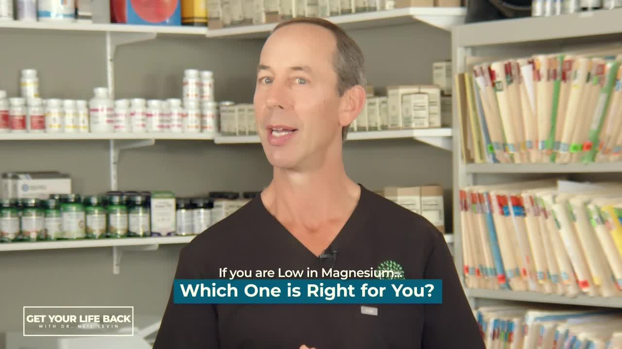 A man in a black shirt is speaking directly to the camera, with shelves of supplements and file folders behind him. Text on the screen asks about magnesium choices.
