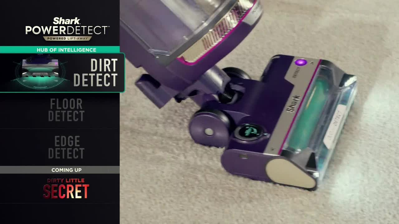 A purple and silver vacuum cleaner head rests on a light-colored carpet. The "Dirt Detect" function is highlighted on a screen, while a Comedy Central-style graphic lists other features.
