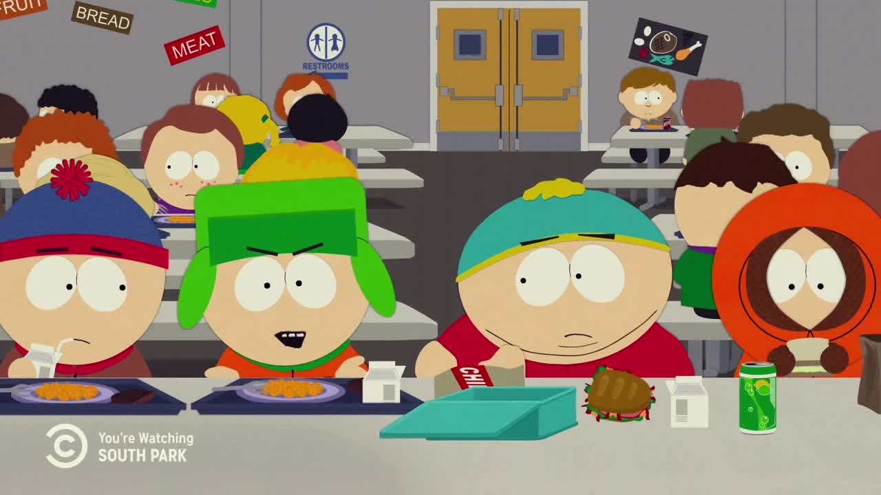Four animated boys sit at a school cafeteria table, each with a plate of food. One of them, wearing a green hat, is mid-sentence with an angry expression.
