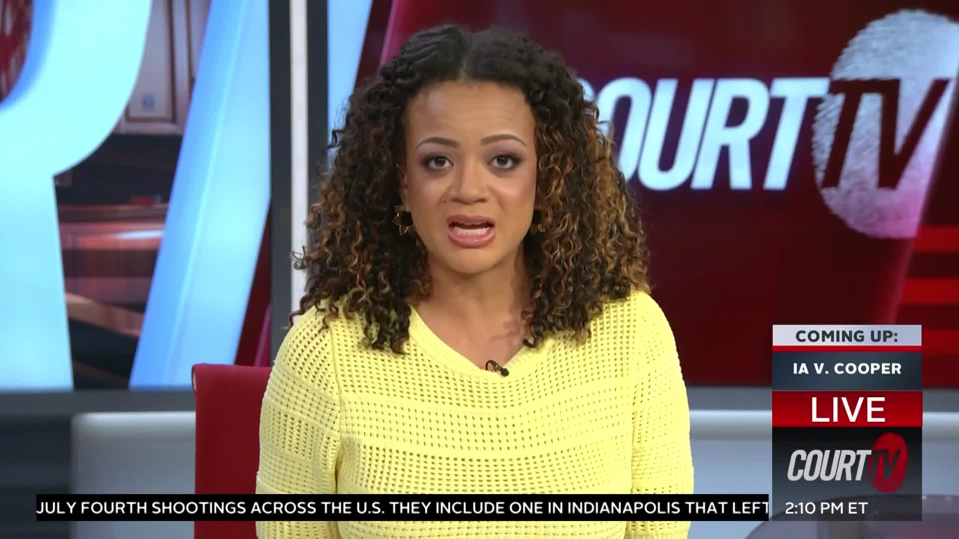 A woman with curly brown hair and a yellow sweater is speaking on Court TV. The screen behind her shows the Court TV logo and a headline about a case called *IA v. Cooper*.
