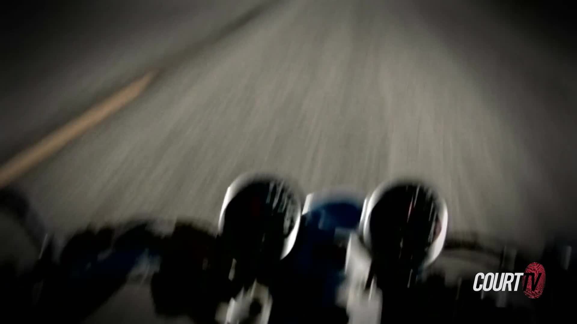 The motorcycle's headlights cut through the darkness as it speeds down the highway. The road ahead is a streaky blur, suggesting a rapid pursuit.