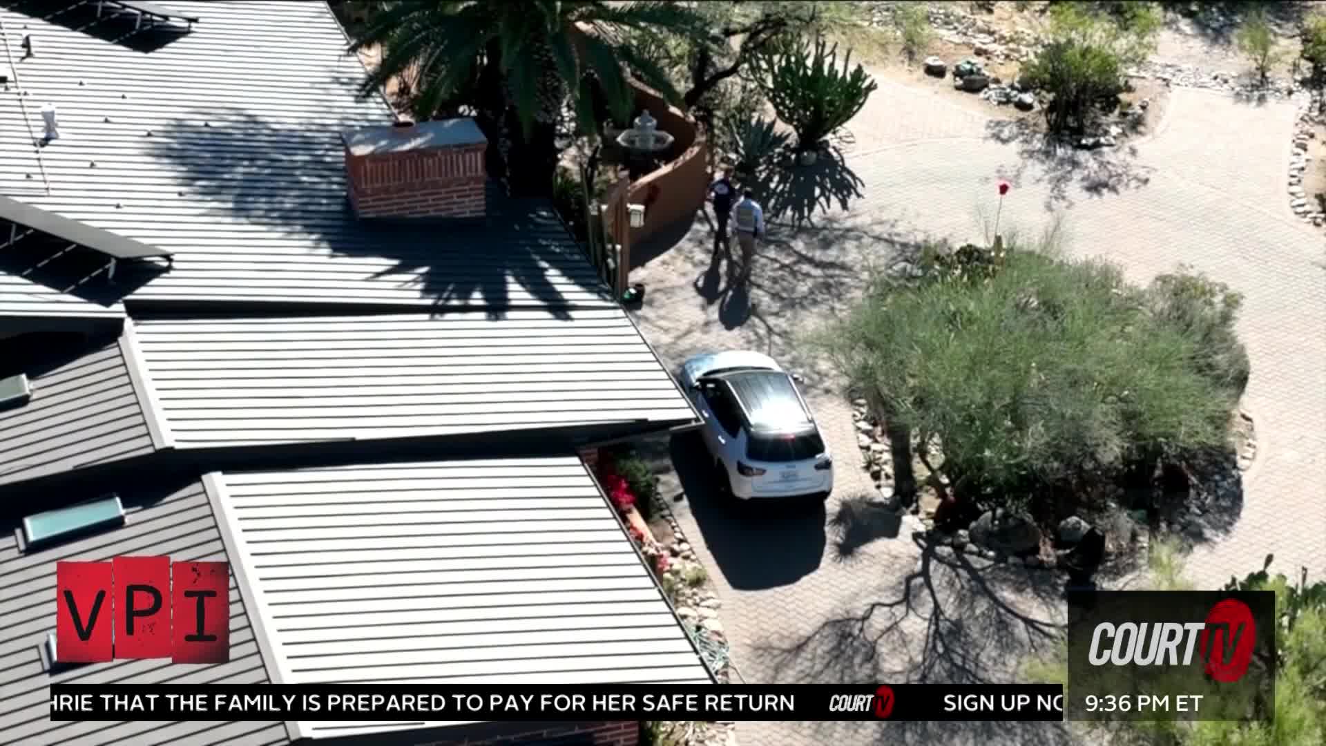A white SUV pulls up to a house where two people stand near the entrance. The sun casts long shadows across the driveway and the corrugated metal roof.