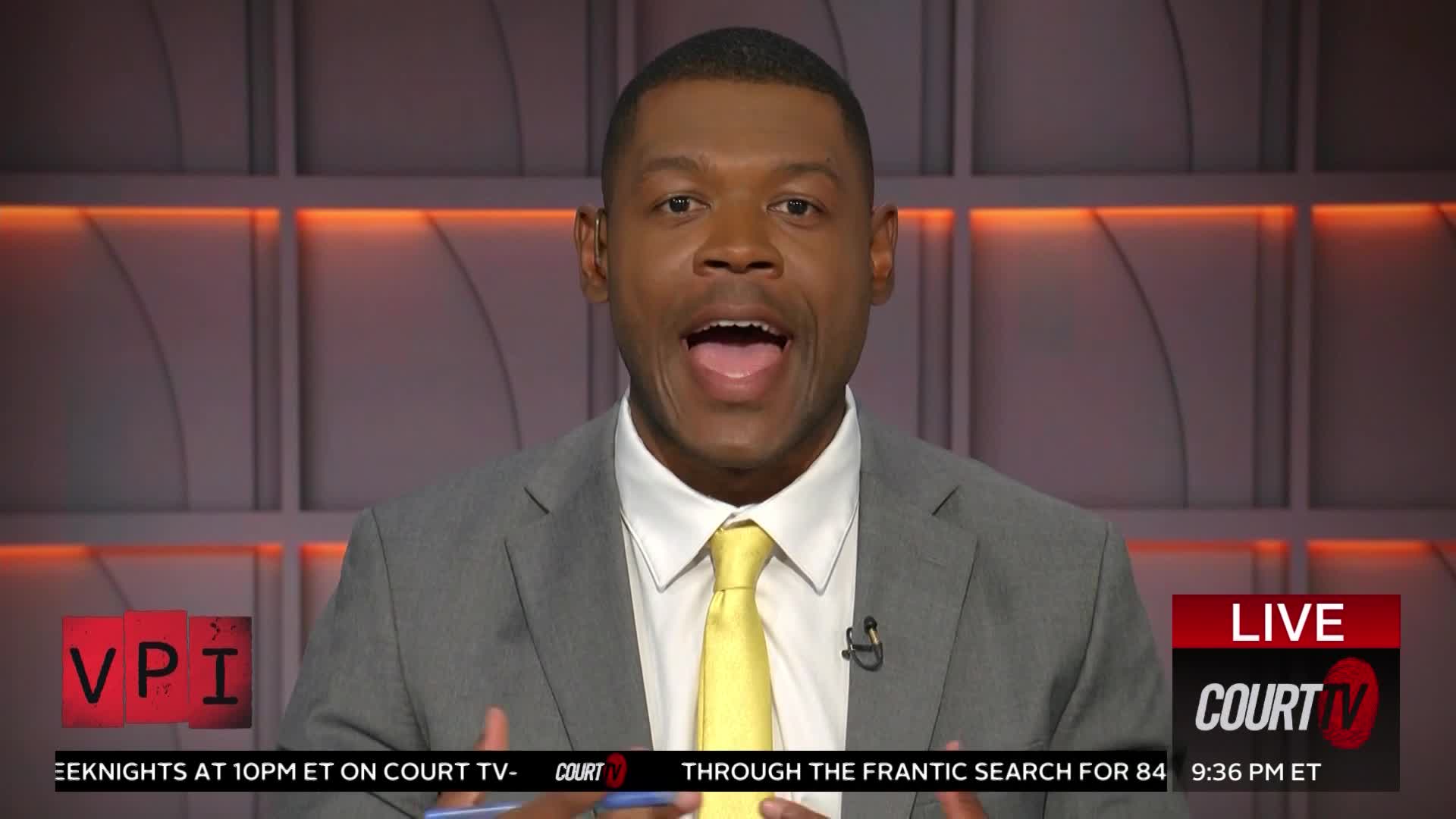 A man in a suit and yellow tie speaks animatedly, his mouth open. Below him, a banner displays "LIVE COURT TV" and the time.