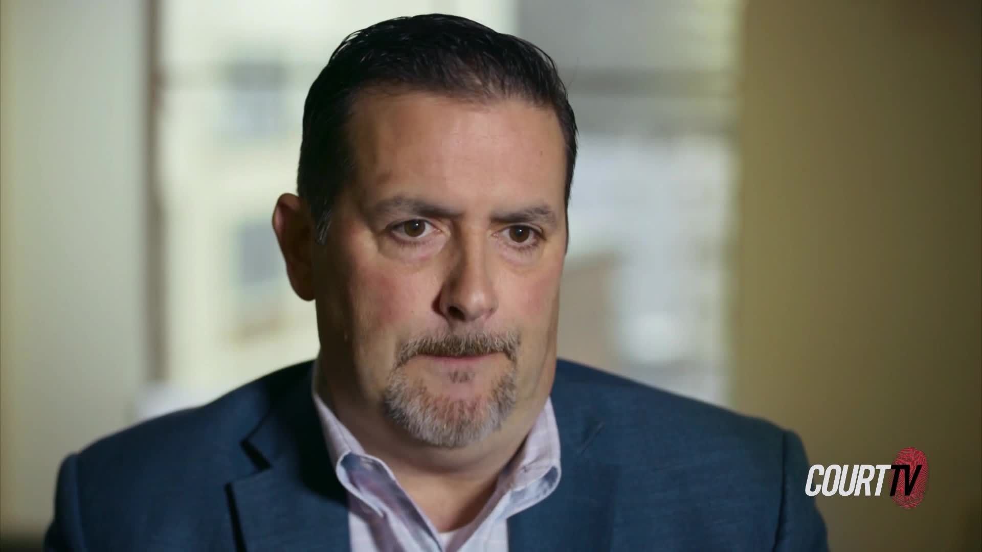 A man in a dark suit jacket and a collared shirt speaks directly to the camera. The Court TV logo appears in the lower right corner.