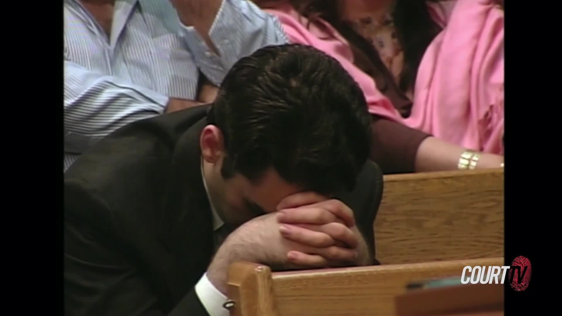A man in a suit bows his head, hands clasped, resting on a wooden pew. The Court TV logo appears in the corner of the screen.