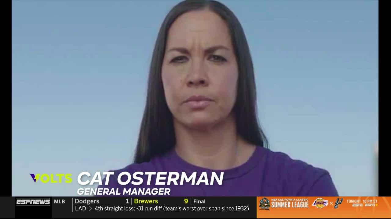 Cat Osterman, the Volts' General Manager, stares directly at the camera, her expression serious. The ESPNews graphic displays baseball scores and a Summer League ad below her.
