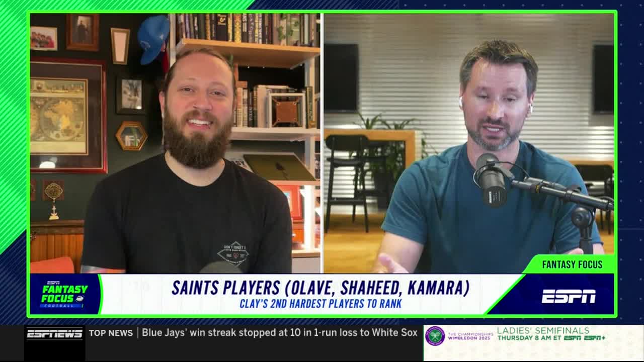Two men are on the screen, each in their own frame, discussing fantasy football on ESPN. The one on the right gestures with his hands while talking, and the other smiles, listening.

