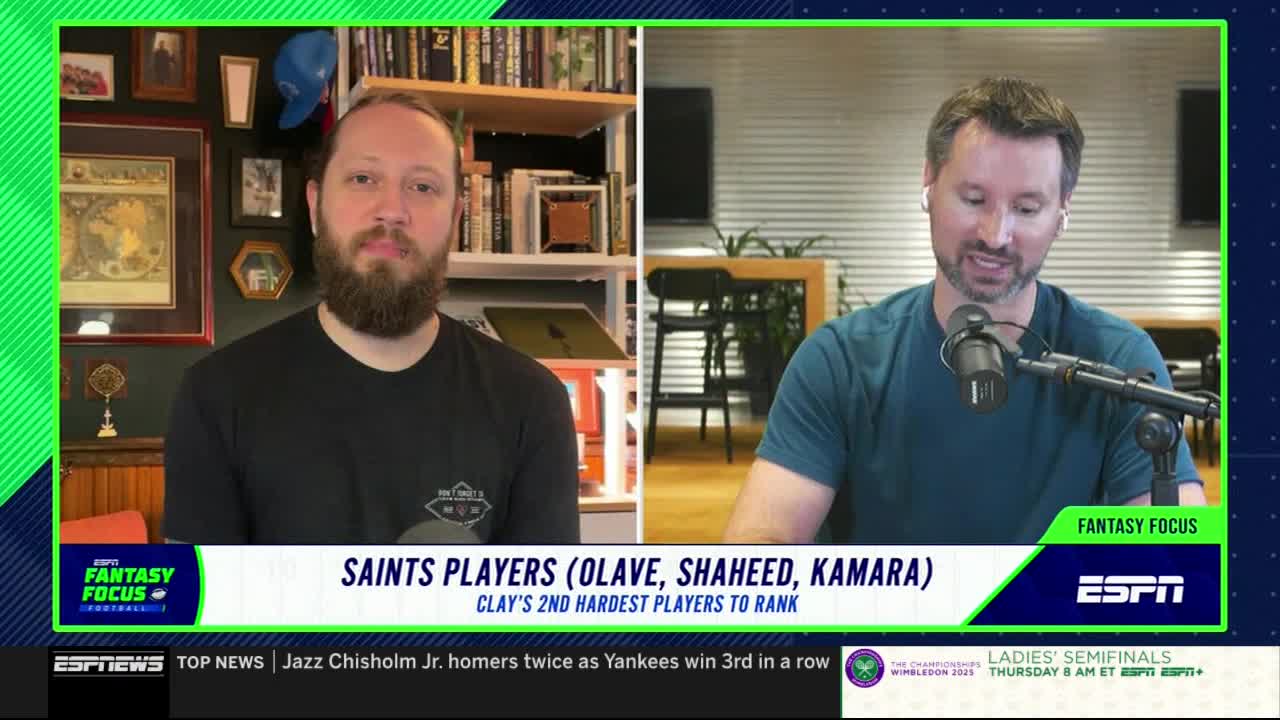 Two men are on a split screen, discussing fantasy football for ESPNews. One man, wearing a black t-shirt, is looking directly at the camera, while the other, in a blue shirt, speaks into a microphone.
