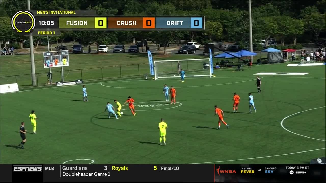 The players in orange and light blue are battling for the ball in the center of the field. ESPNews is showing the OmegaBall Men's Invitational, with the score tied at zero.
