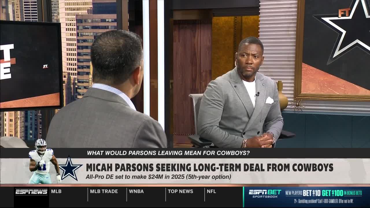 On ESPNews, two men in suits are seated, facing each other in a studio. A graphic below them discusses Micah Parsons and his contract negotiations with the Dallas Cowboys.
