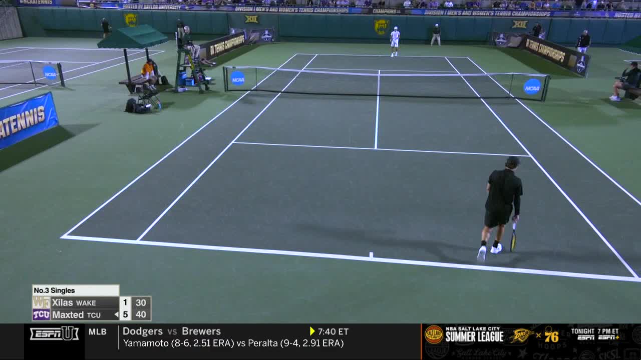 A player in black prepares to serve, racket held low, while his opponent stands ready on the opposite side of the court. The score is displayed on the ESPNU graphic at the bottom of the screen.
