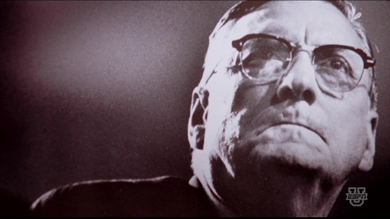 A man with thick-rimmed glasses stares intently, his expression serious. The ESPNU logo is visible in the corner, suggesting a broadcast from the United States.

