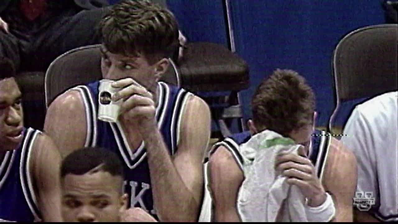 A player in a blue jersey is drinking from a paper cup, while another wipes his face with a towel. The ESPNU logo is visible in the corner.
