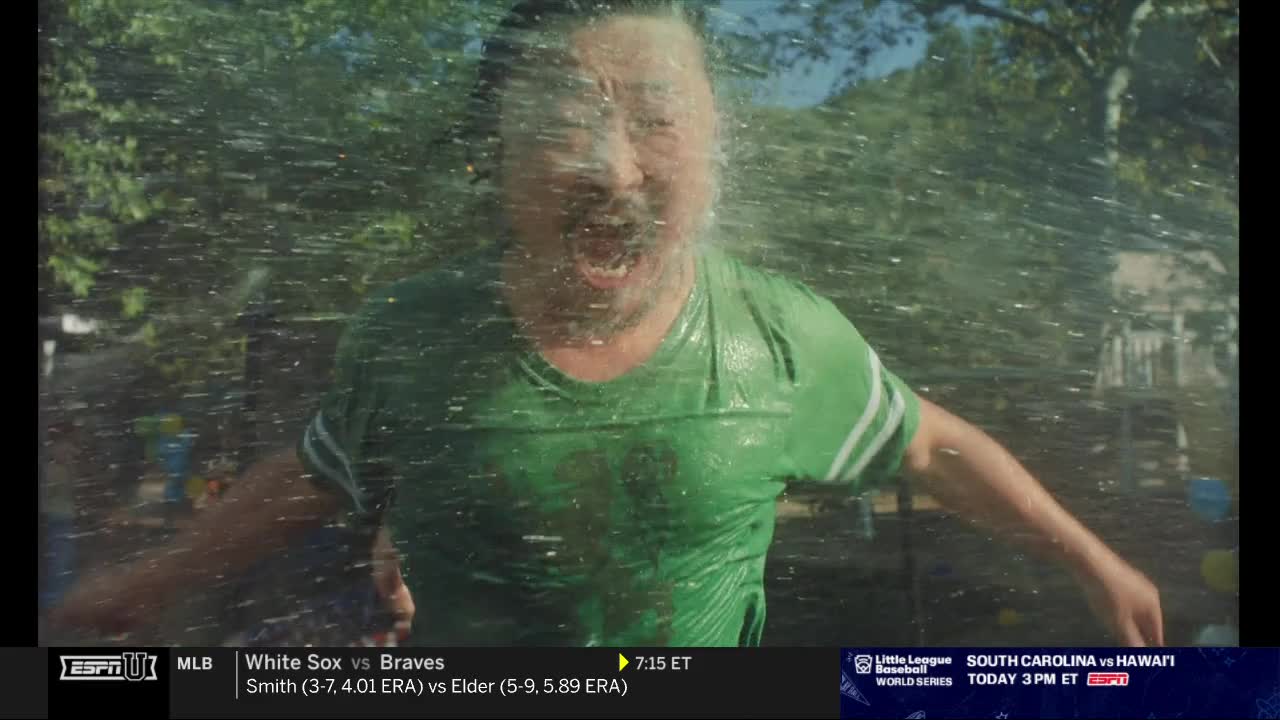 A man in a green shirt is getting soaked by a spray of water, his face contorted in surprise. The ESPNU graphic at the bottom of the screen suggests this is a commercial break.
