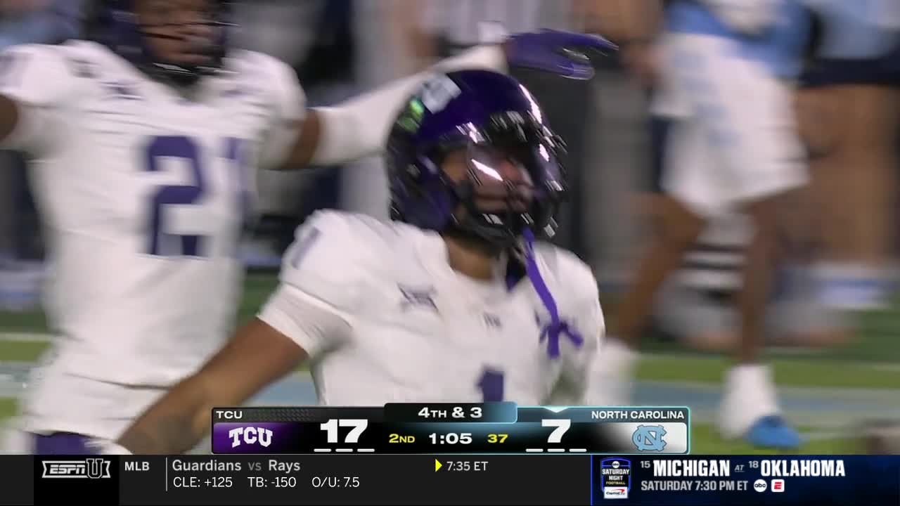 A TCU player in a purple helmet celebrates, his arms raised as another player approaches. The scoreboard on ESPNU shows the score is 17-7 in the second quarter.
