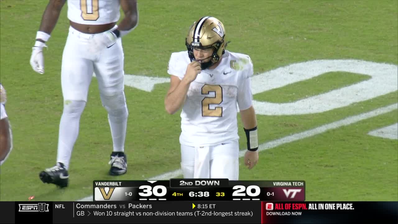 A Vanderbilt quarterback, number 2, stands on the field, fingers touching his mouth.  The scoreboard shows the Commodores leading Virginia Tech in the fourth quarter on ESPNU.
