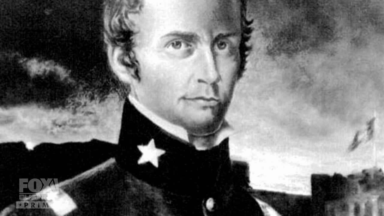 A black-and-white portrait of a man in a military uniform appears on the Fox Business Network screen. The image is set against a backdrop of a cloudy sky and a distant fortress.
