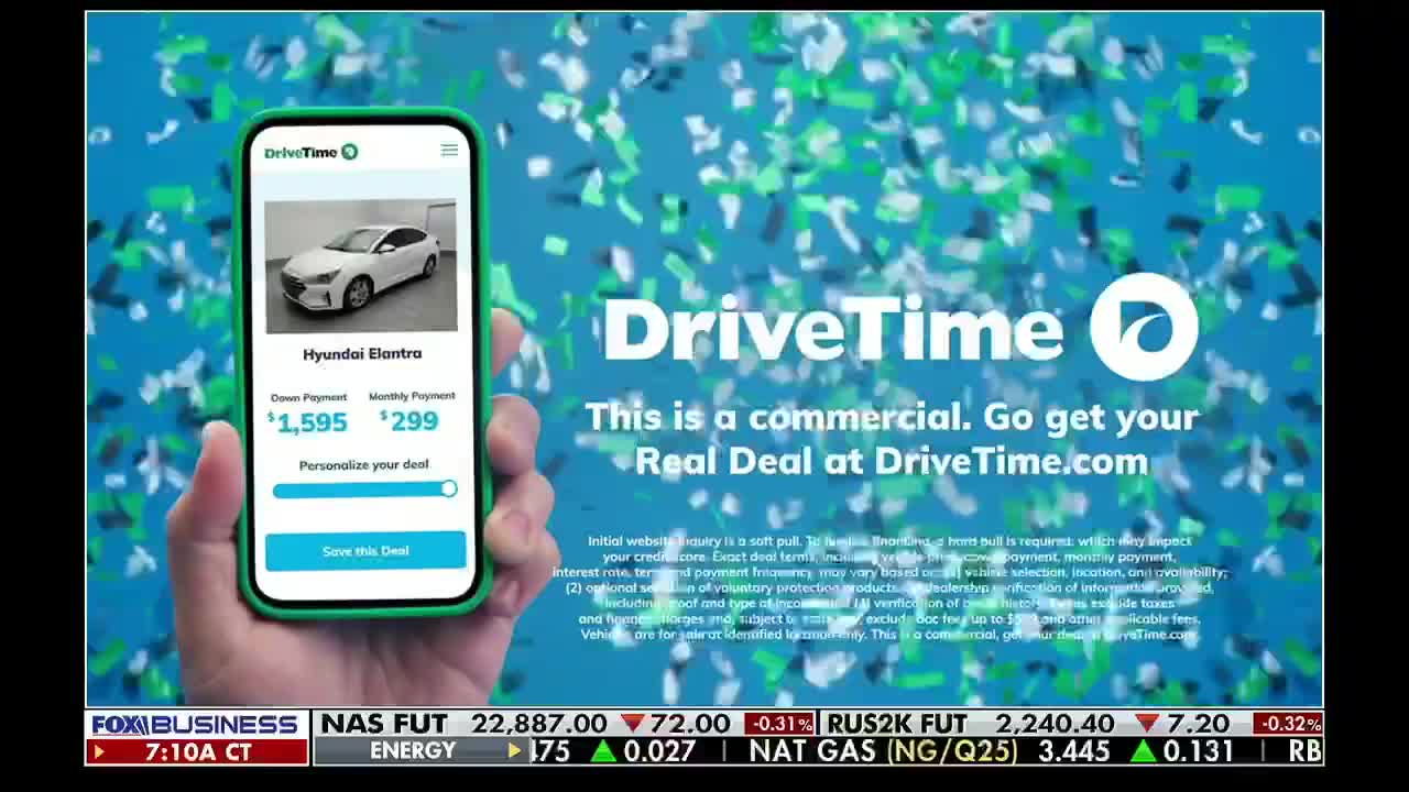 A hand holds a smartphone displaying a DriveTime advertisement for a Hyundai Elantra, with a down payment and monthly payment listed. The Fox Business Network logo is visible at the bottom, indicating this is a commercial break.
