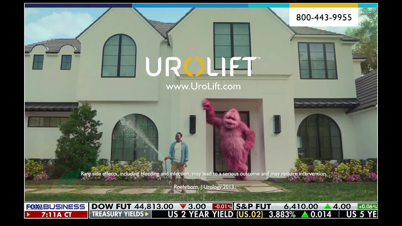 A man waters the lawn as a pink, furry creature waves from the doorway of a large house. This is a commercial on Fox Business Network, advertising UroLift.
